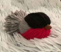 oiseau fait avec de la laine rouge, nore et grise